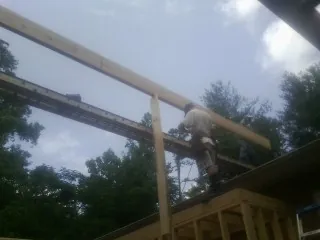 Carpenter setting a ridge beam over a new addition frame — Ice Dam Removal by Roofing Brothers in Gallatin Gateway