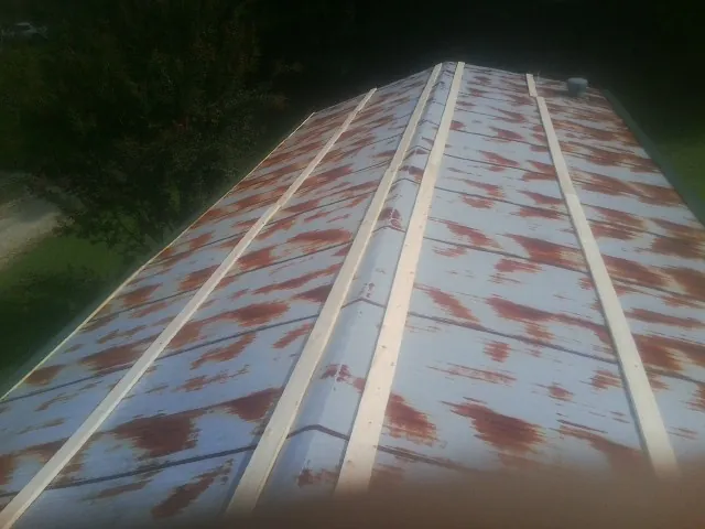 Rusted metal roof panels with new wood purlins before replacement — Storm Damage Roof Repair in Gallatin Gateway by Roofing Brothers