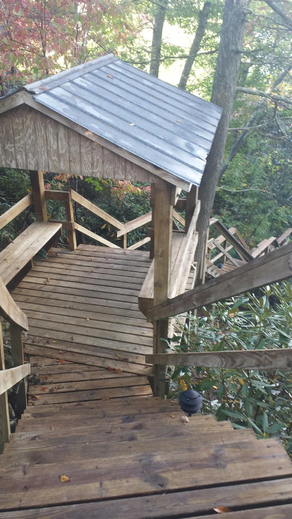 Metal roofed shelter over wooden steps on a wooded walkway — Skylight Repair & Installation work by our crew in Gallatin Gateway