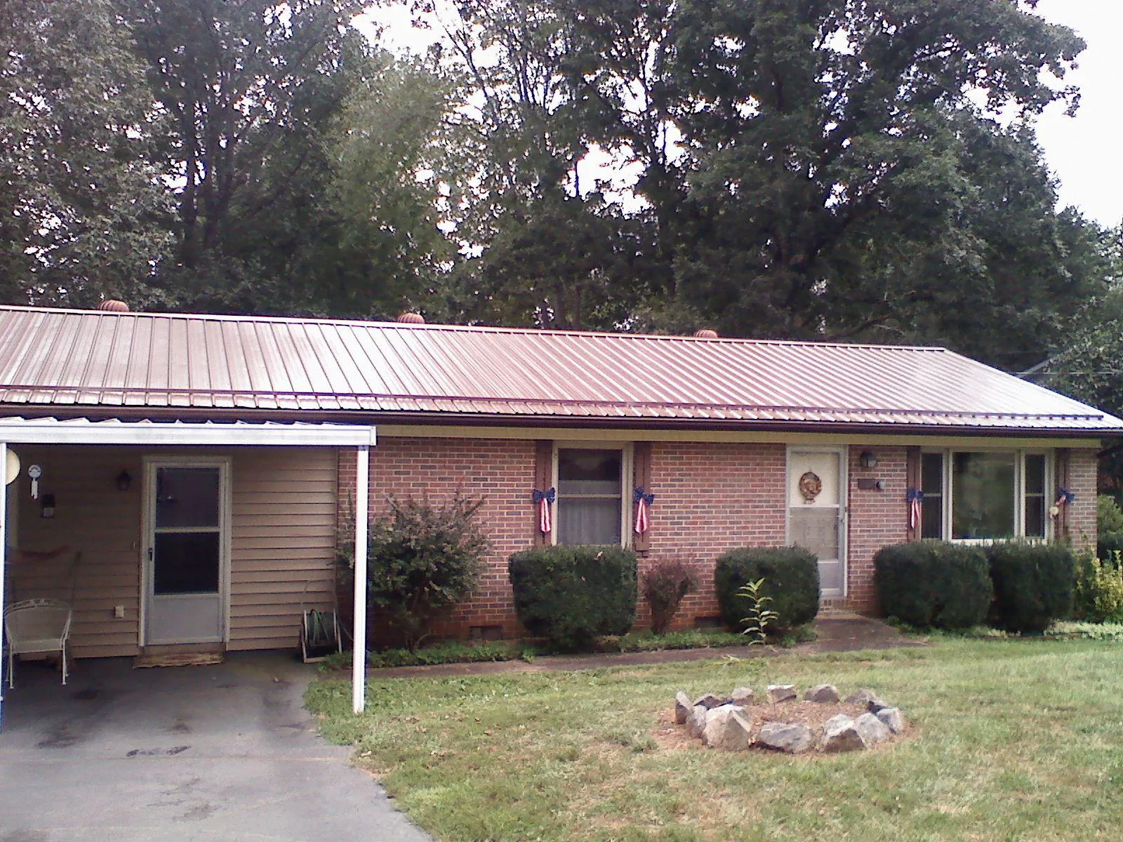 Bronze metal roof and carport on a brick ranch home — Roof Repair work by our crew in Gallatin Gateway